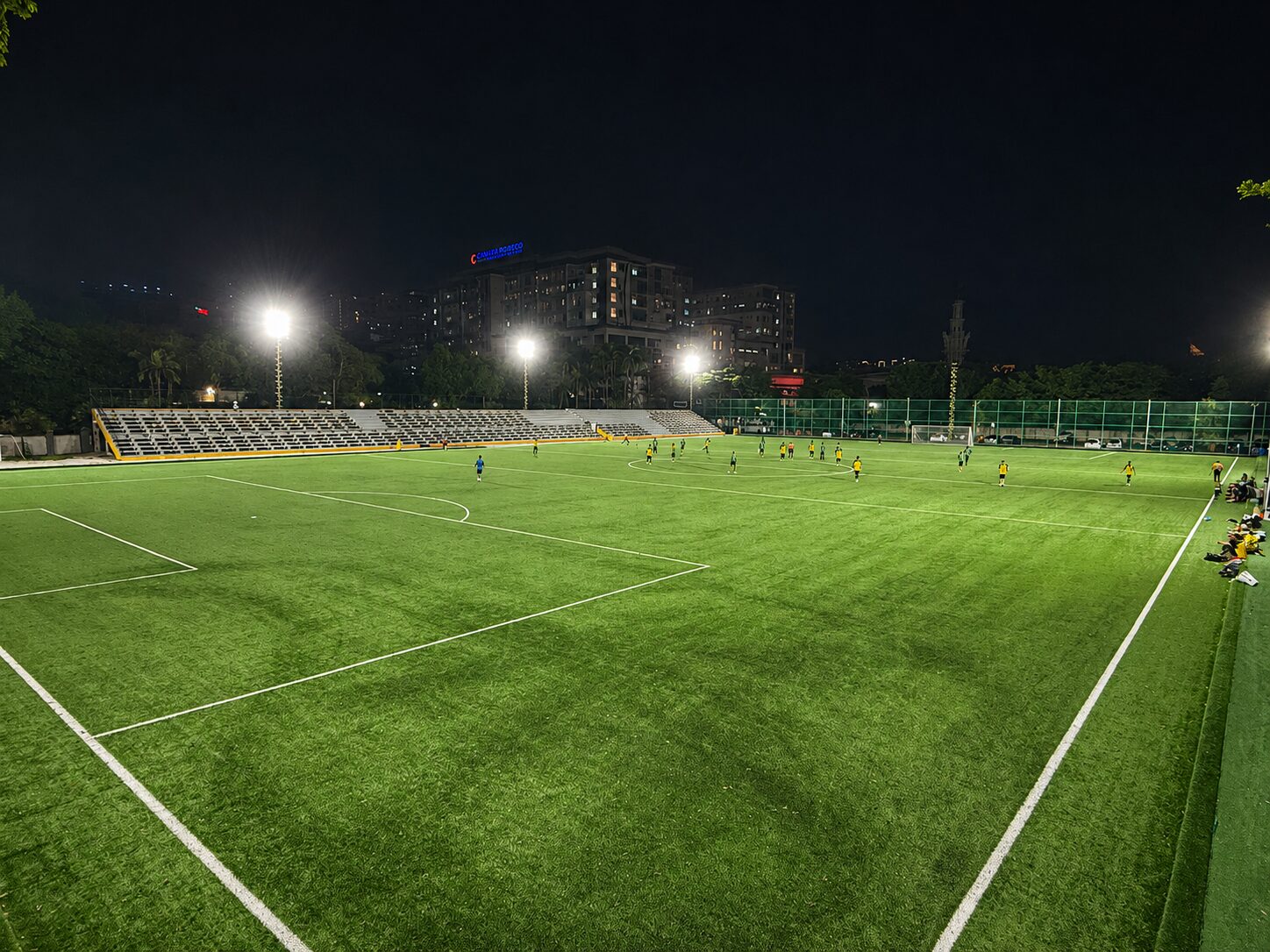Players on the SJM1 Arena football pitch during a night match
