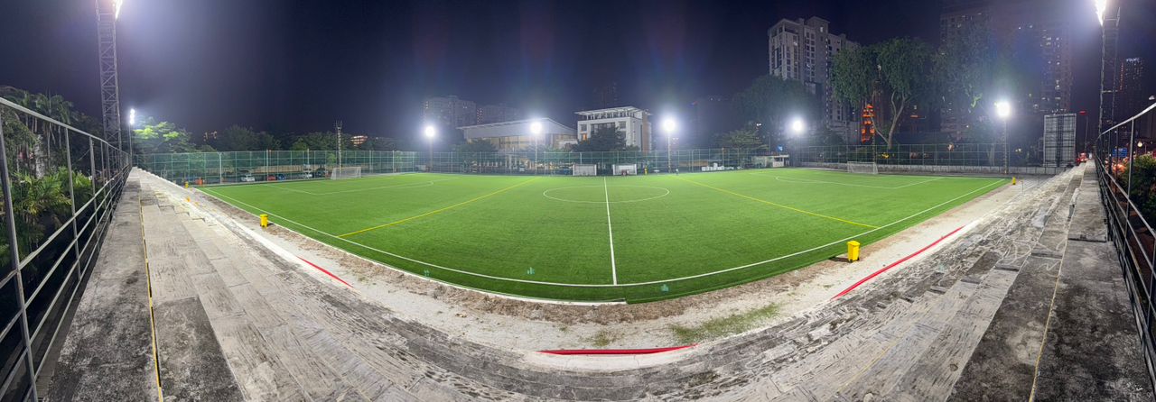 Wide panoramic view of the SJM1 Arena football turf under stadium lights at night